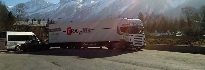 Travadri-vrachtwagen met koeloplegger onderweg in de bergen